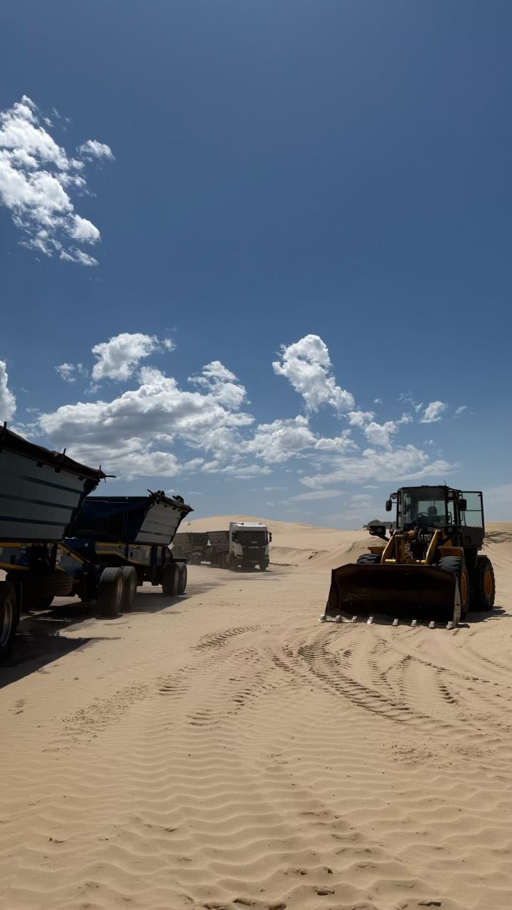 CWG fleet trucks and Komatsu loader on sand dune site